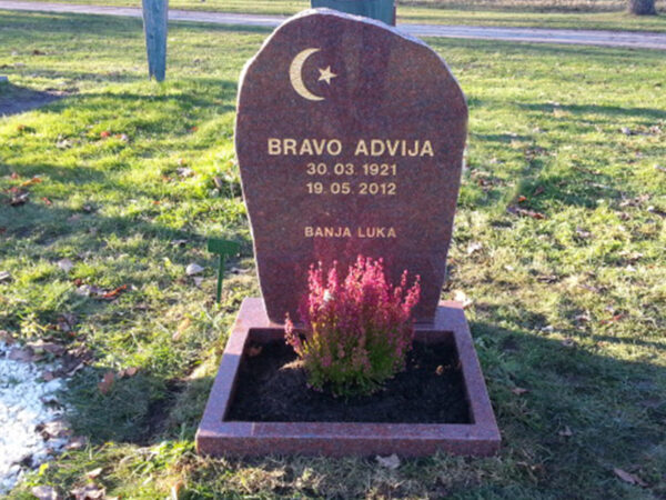 E056 in Indian red granite. Polished front and roughly finished sides, polished flower border, and recessed gilded engraving.