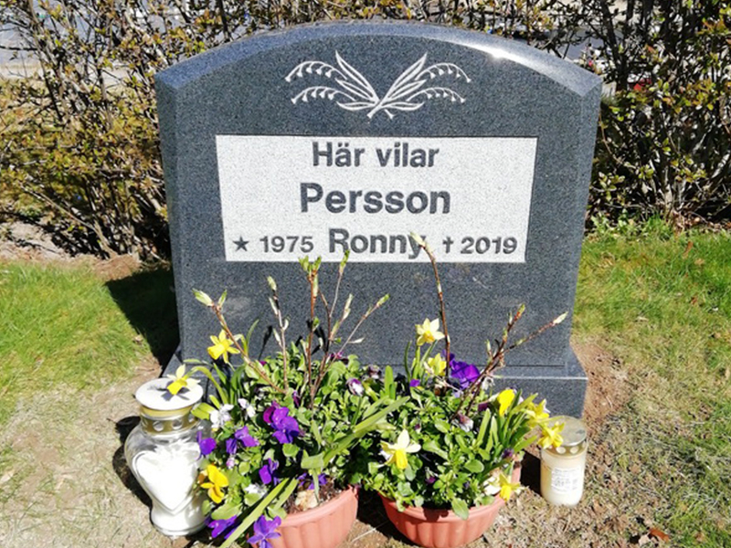 E041 med sockel. Mörkgrå polerad granit med upphöjd text och försänkt efterhuggen dekor.