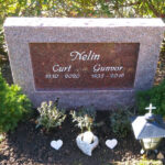 E074 in Indian red granite. Recessed inscription painted white in the polished surface.