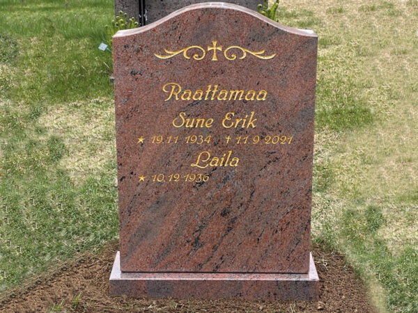 E009 i polerad rödflammig granit. Text och dekor är försänkta och förgyllda.
