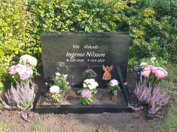 E074 in fully polished black granite. Recessed inscription painted antique white, with polished flower border.