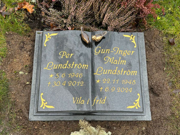 E063 in polished black granite. Recessed, gold-painted engraving and bronze sparrows at the top.