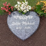 E022 in polished Labrador granite. Text and decoration are recessed and painted silver.