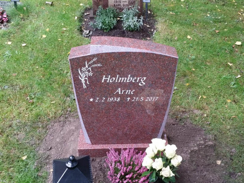 E006 i polerad indisk röd granit med mattslipade detaljer. Gravyren försänkt målad antikvit.