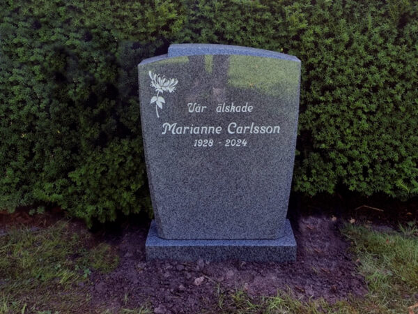 EN006 i polerad grå Kurugranit med mattslipad fas. Anpassad i storlek, försänkt antikvit gravyr.